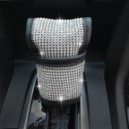 Car gear shift cover accessory in black with textured design, compatible with various vehicle gear sticks.
