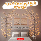 Warm indoor tree branch light from سوق كوم featuring illuminated branches for decorative interior lighting.