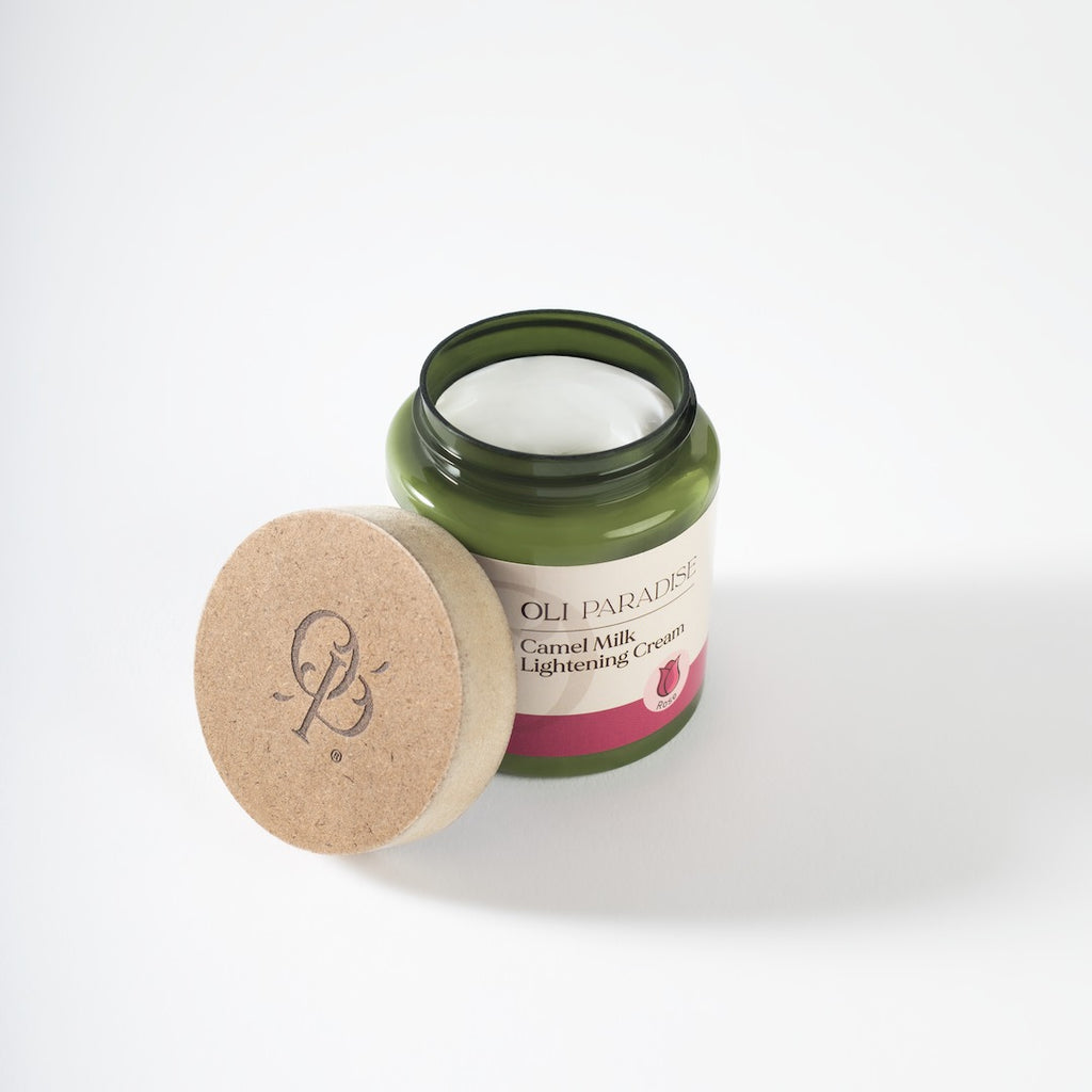 Cream jar of أولي باراديس لبن جمل ورد for skincare, featuring a pink and white packaging with Arabic text.